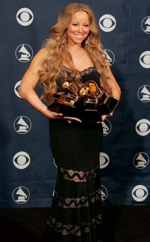 Mariah Carey no tapete vermelho segurando seus prêmios do Grammy