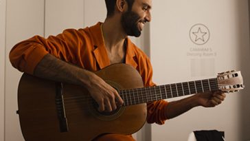 Silva sorri e segura seu violão no camarim de show em Portugal