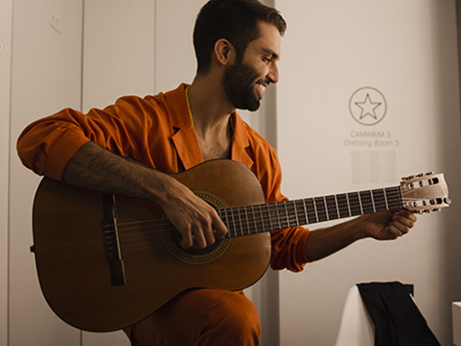 Silva sorri e segura seu violão no camarim de show em Portugal