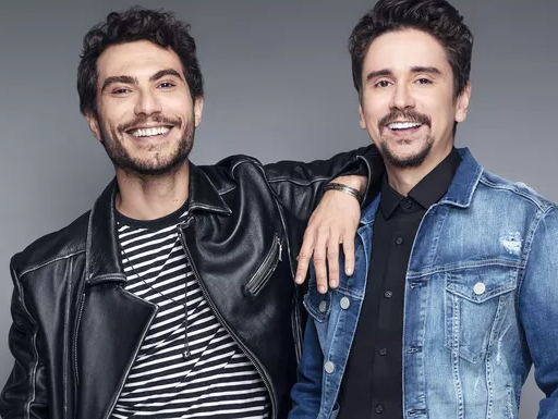 Bruninho de jaqueta preta e Davi de jaqueta jeans posam em foto promocional