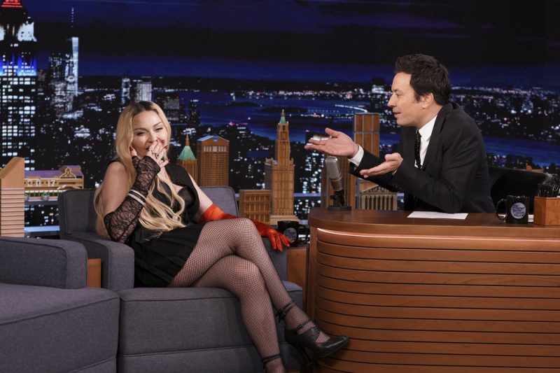 Madonna sensualiza e deita na bancada de apresentador de TV