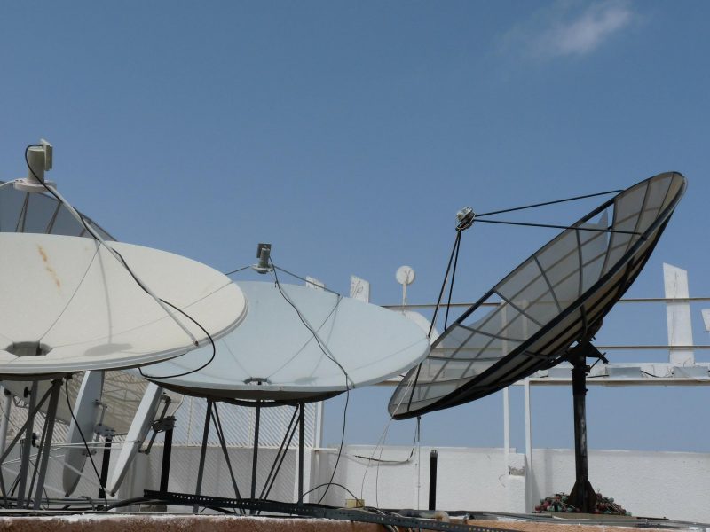 Quatro antenas parabólicas no telhado de um edifício